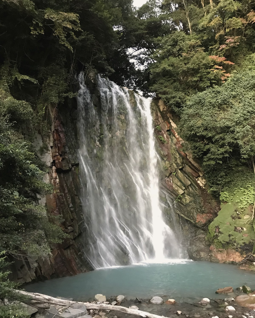 丸尾滝の全景。高さ23mの崖を簾のように水が落ち、青白い滝つぼに注ぐ