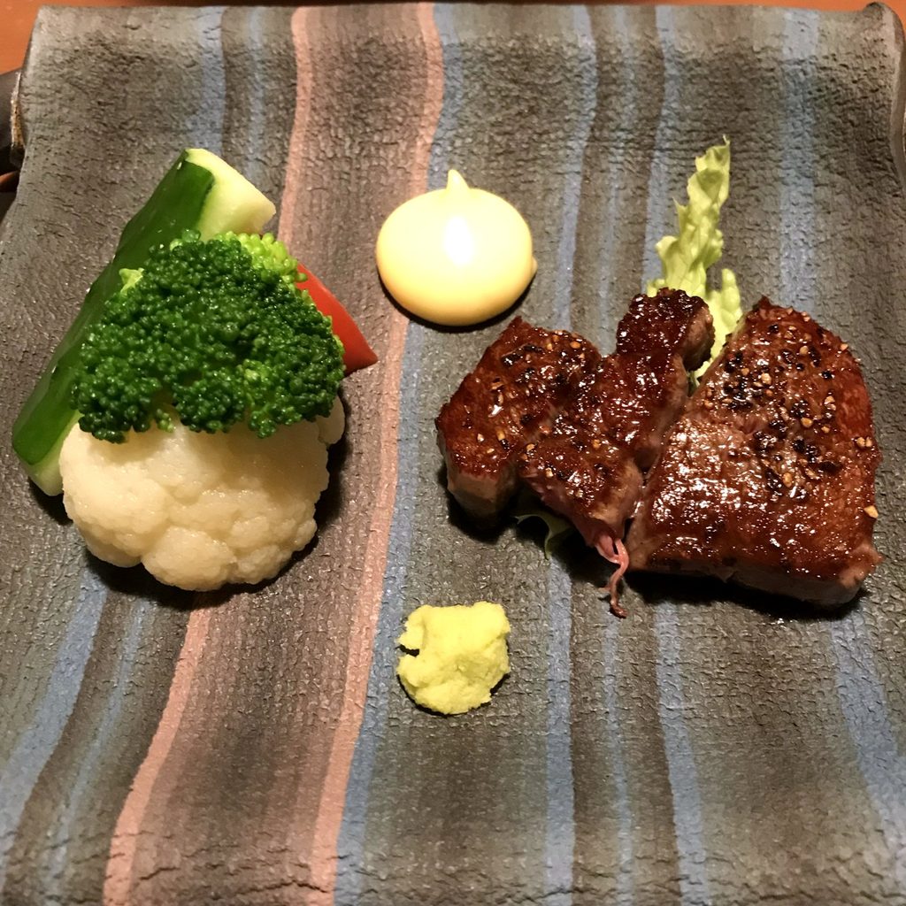 摘み草の宿こまつの夕食の黒毛和牛のヒレステーキ。温野菜とわさびが添えられている