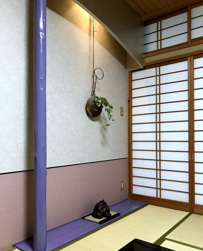 摘み草の宿こまつの客室の床の間。掛け花入れに草花が生けてある